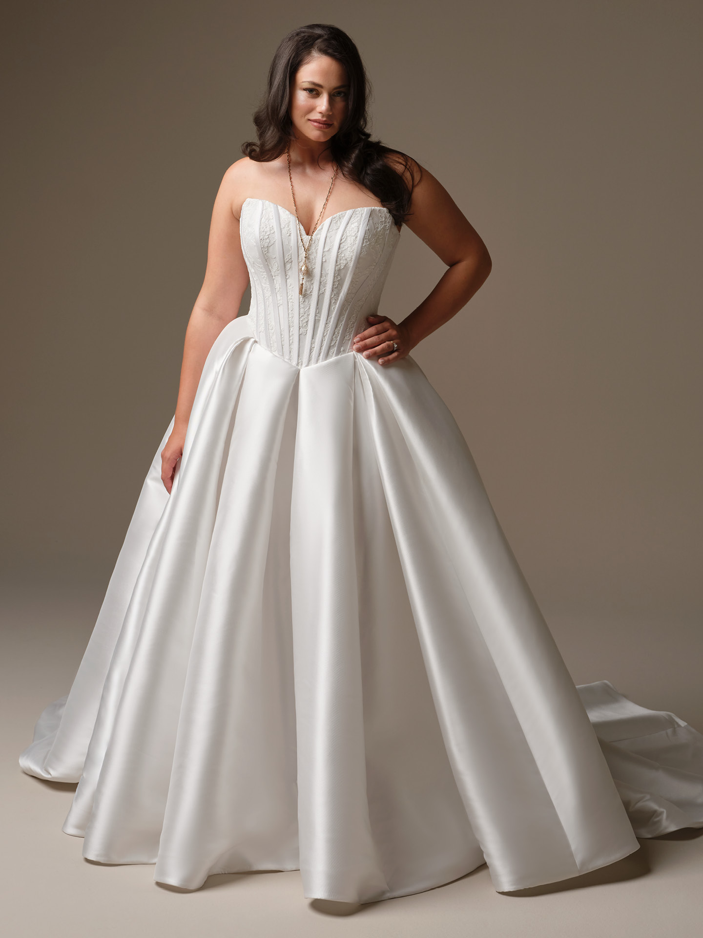 Maggie Sottero Ashland ballgown wedding dress with a strapless basque waist bodice and voluminous satin skirt, highlighting a defined waist and dramatic, romantic shape.