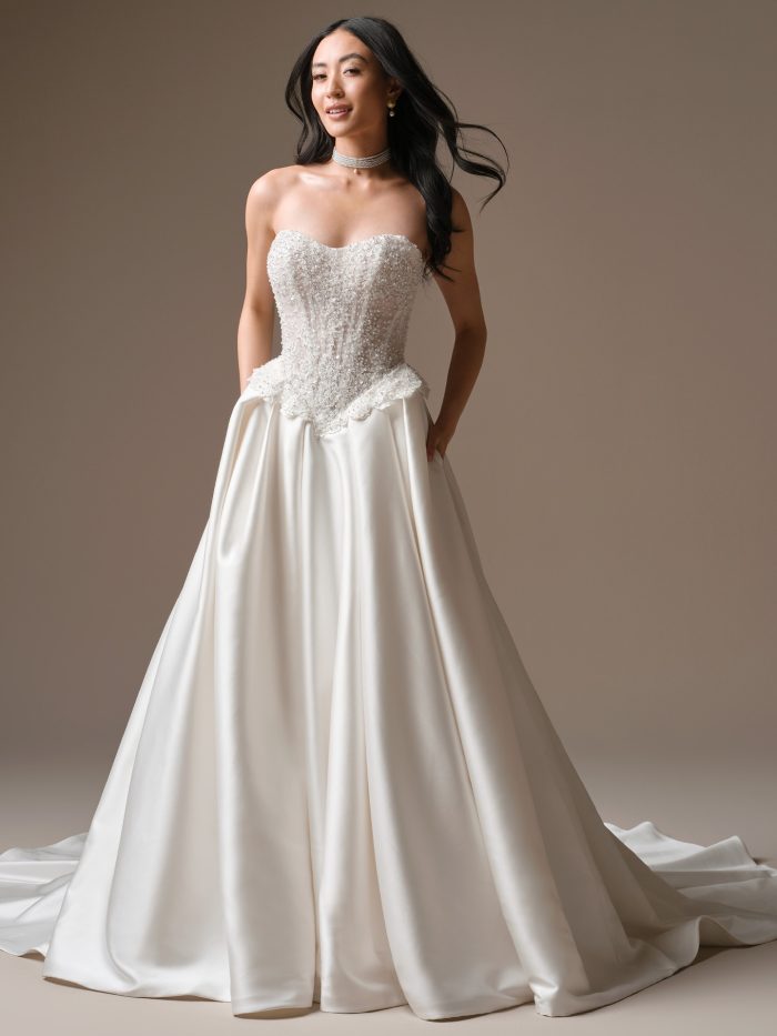 Strapless basque waist ball gown wedding dress with beaded lace bodice and satin skirt.
