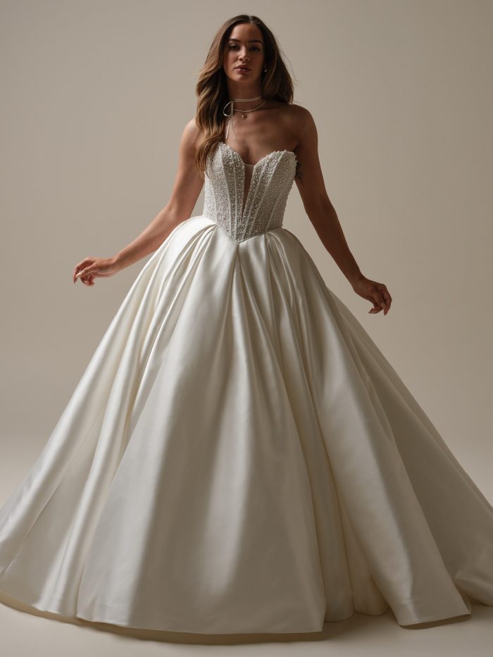 Tina strapless ballgown wedding dress by Maggie Sottero with pearl beaded bodice, basque waist, and full satin skirt.