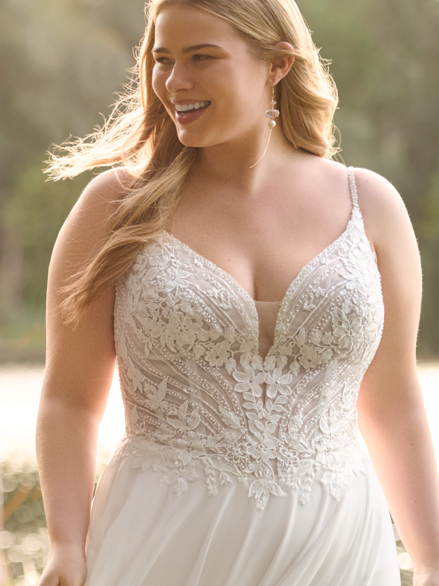 Close-up of plus size Rebecca Ingram Finley A-line wedding dress with a structured lace bodice, delicate straps, and sculpting support, showcasing a flattering fit