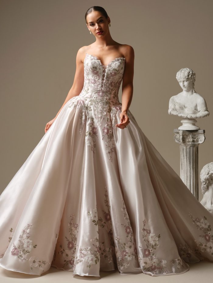 Alvarez by Sottero and Midgley floral ballgown wedding dress with plunging illusion V-neckline, embroidered floral motifs, and full organza skirt with pockets.