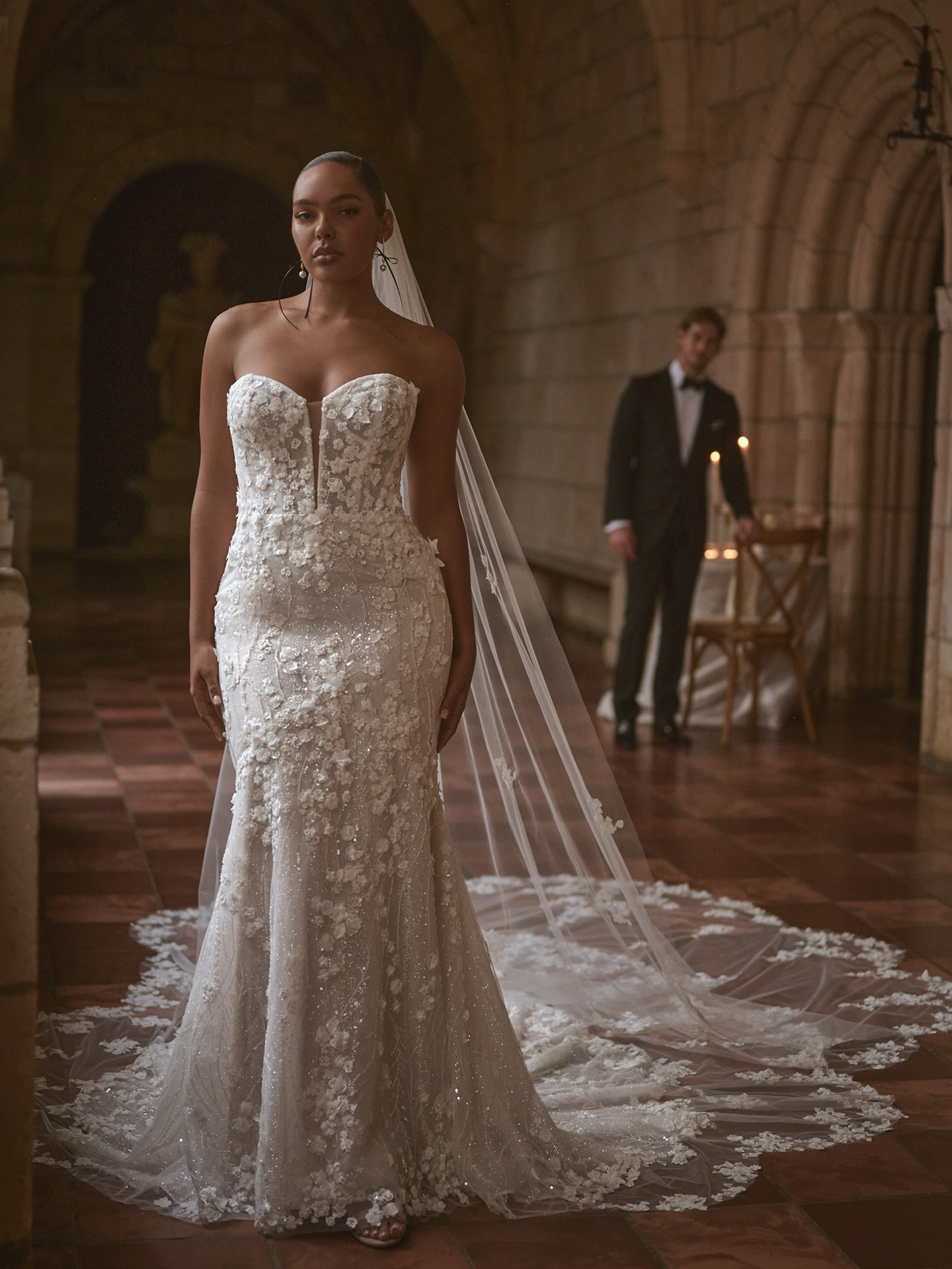 Sottero and Midgley Noor sheath wedding dress featuring a strapless sweetheart neckline, illusion plunge, and intricate 3D floral lace over a sleek, body-skimming silhouette with a soft, flowing train.