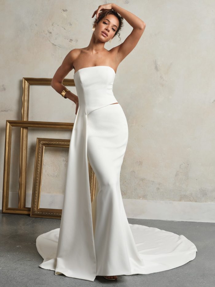 Sakura strapless sheath wedding dress by Sottero and Midgley featuring a modern fitted silhouette and asymmetrical draped detail.