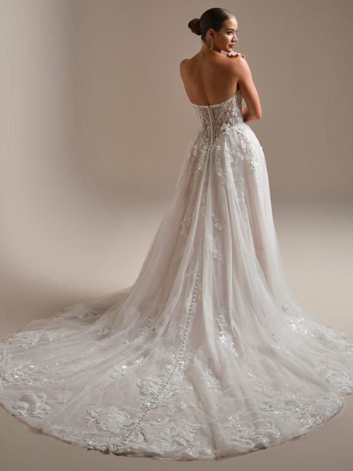 Back view of Twilight Lane by Sottero and Midgley A-line wedding dress featuring illusion lace back, 3-D beaded lace motifs, glitter tulle skirt, and chapel train.