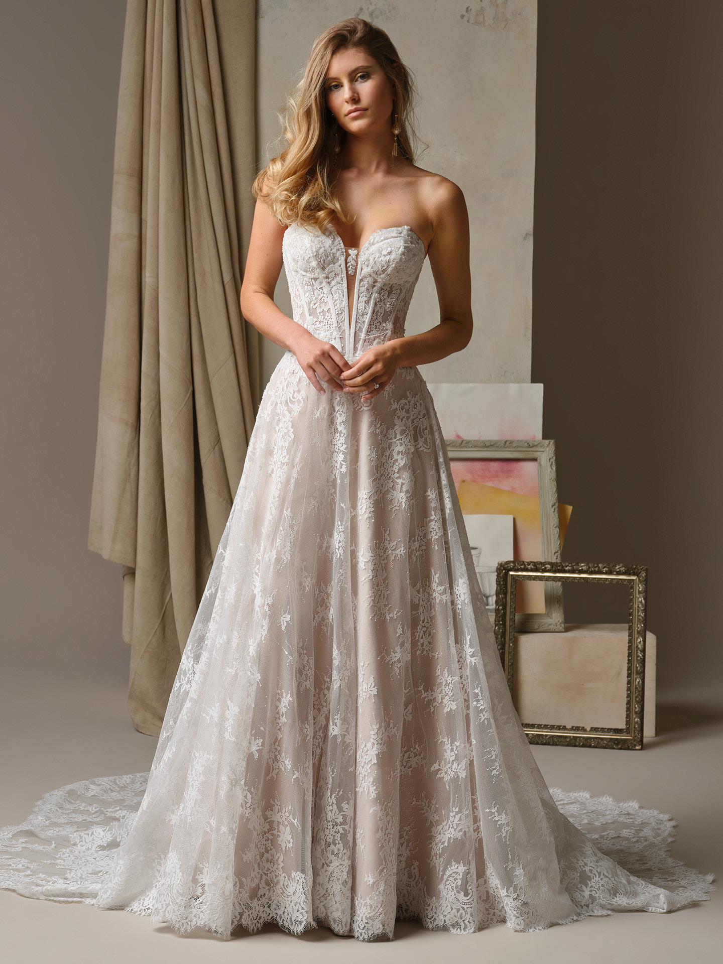 Lucca by Maggie Sottero A-line wedding dress with strapless sweetheart neckline, illusion plunge bodice, and soft lace overlay skirt with romantic floral detailing