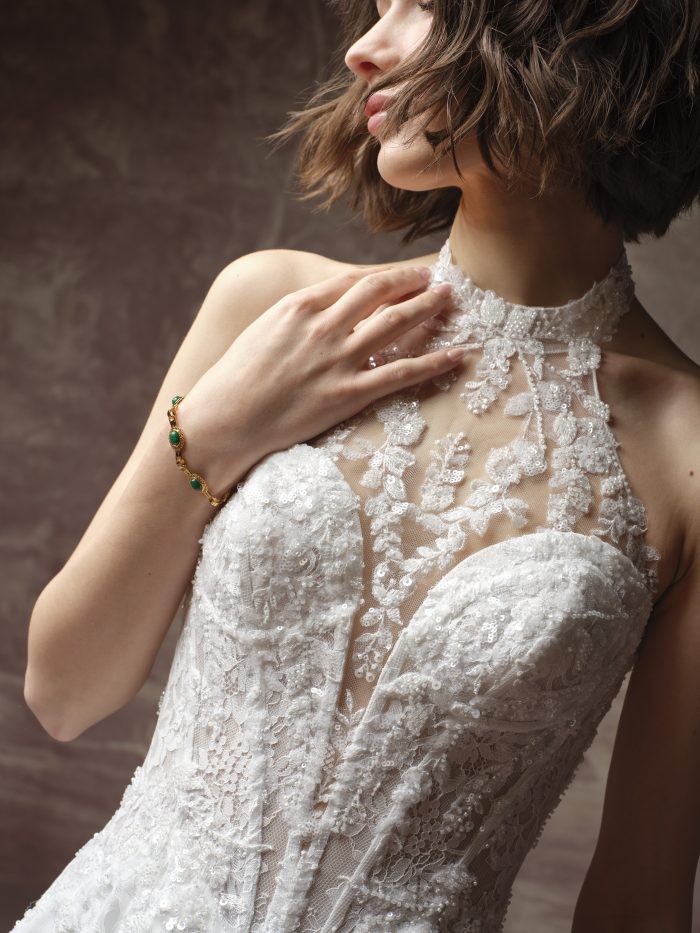 Lucca Marie A-line wedding dress by Maggie Sottero in a close-up view highlighting the illusion halter neckline, intricate lace appliqués, and subtle beading over a structured sweetheart bodice.