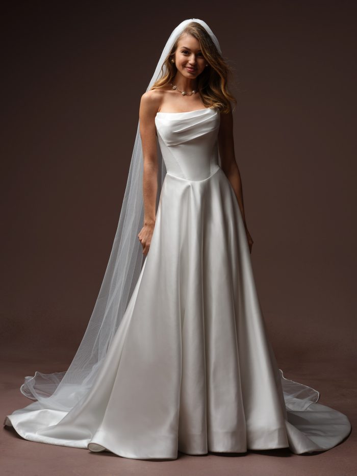 Maggie Sottero Morganna Marie A-line wedding dress, front view on model — strapless draped satin bodice with clean A-line skirt and cathedral veil.