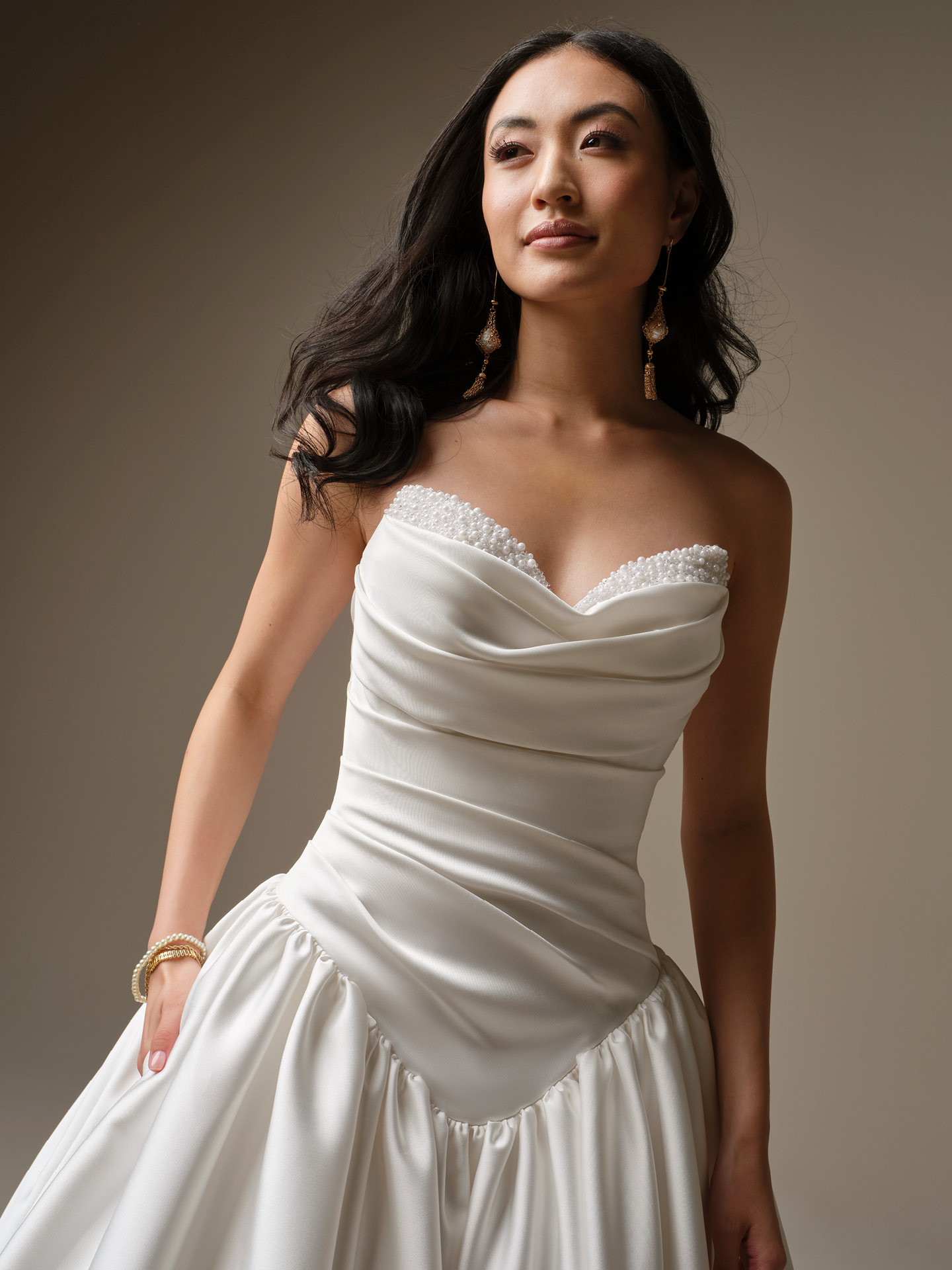 Close-up of Pasadena strapless satin wedding dress with draped bodice, pearl-trim neckline, and structured waist