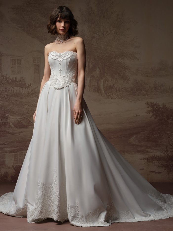 Maggie Sottero Seattle ballgown wedding dress, front view on model — strapless beaded lace bodice with full satin ballgown skirt and lace-trimmed train.