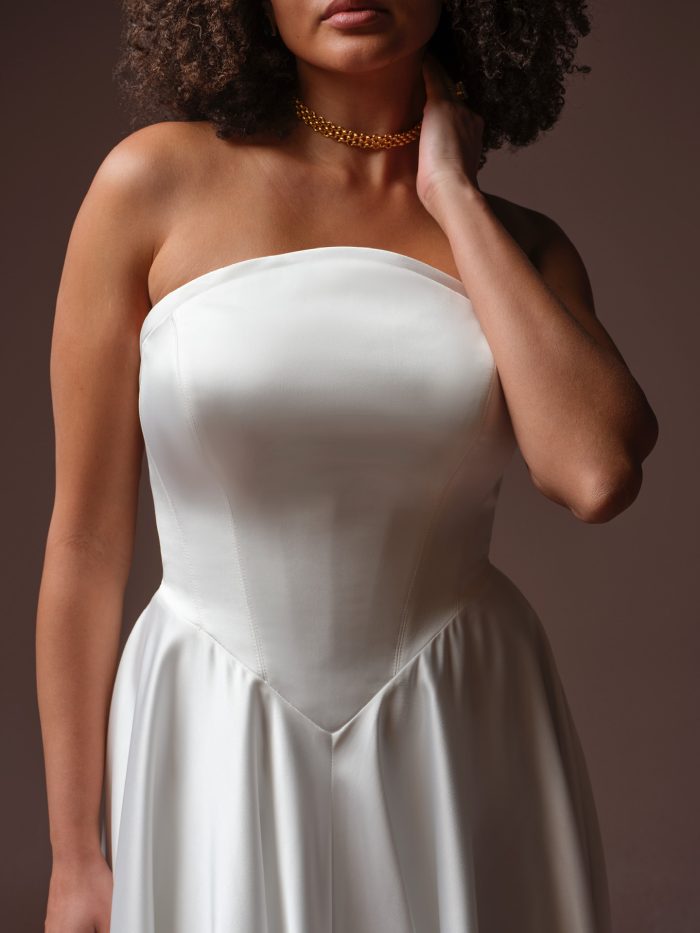 Maggie Sottero Tiffany A-line wedding dress, close-up detail — strapless satin bodice with clean seaming and A-line skirt.