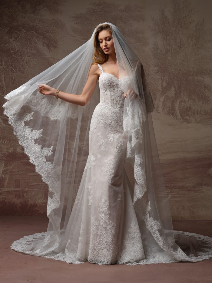 Rebecca Ingram Esmeralda Lane wedding dress with cathedral veil — fitted lace mermaid gown with sweetheart neckline, shown with a lace-edged tulle veil.