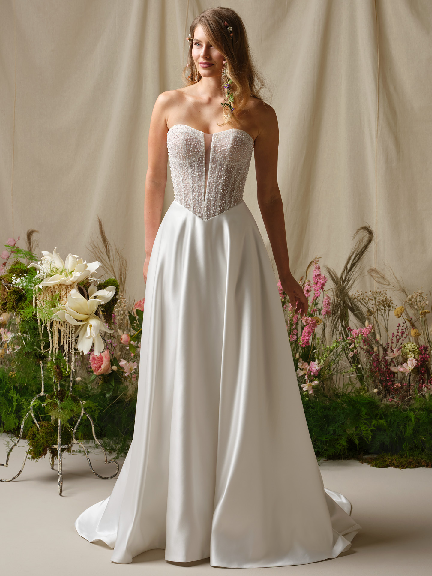 Marty A-line wedding dress by Rebecca Ingram with strapless beaded corset bodice and flowing satin skirt