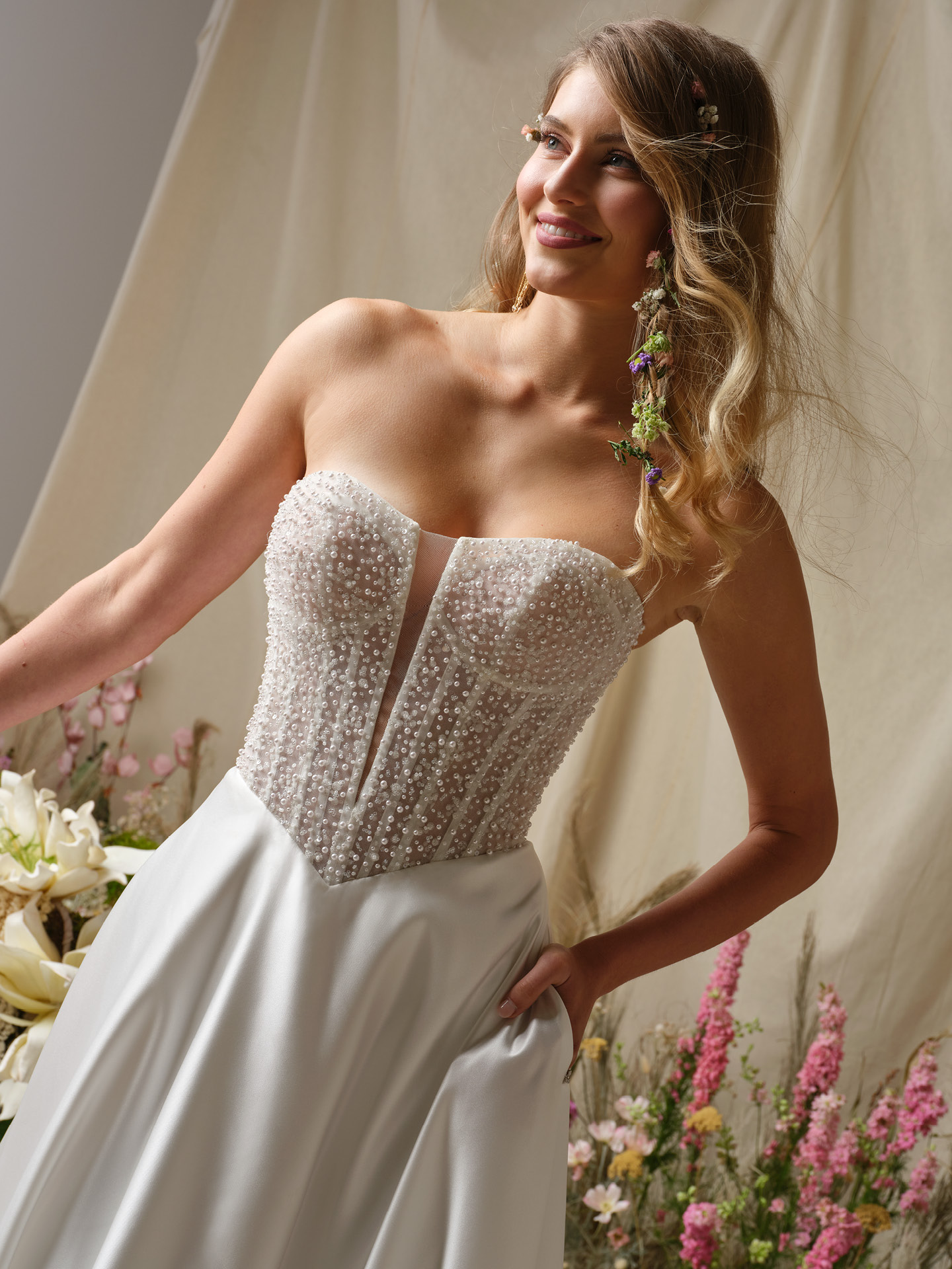Close-up of Marty strapless wedding dress by Rebecca Ingram with beaded corset bodice, sheer plunge neckline, and structured fit