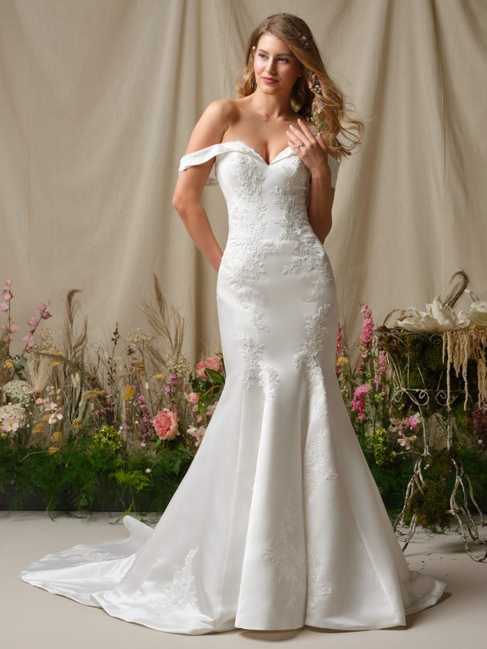 Miley by Rebecca Ingram off-the-shoulder fit-and-flare wedding dress with satin silhouette, lace appliqué accents, and soft train