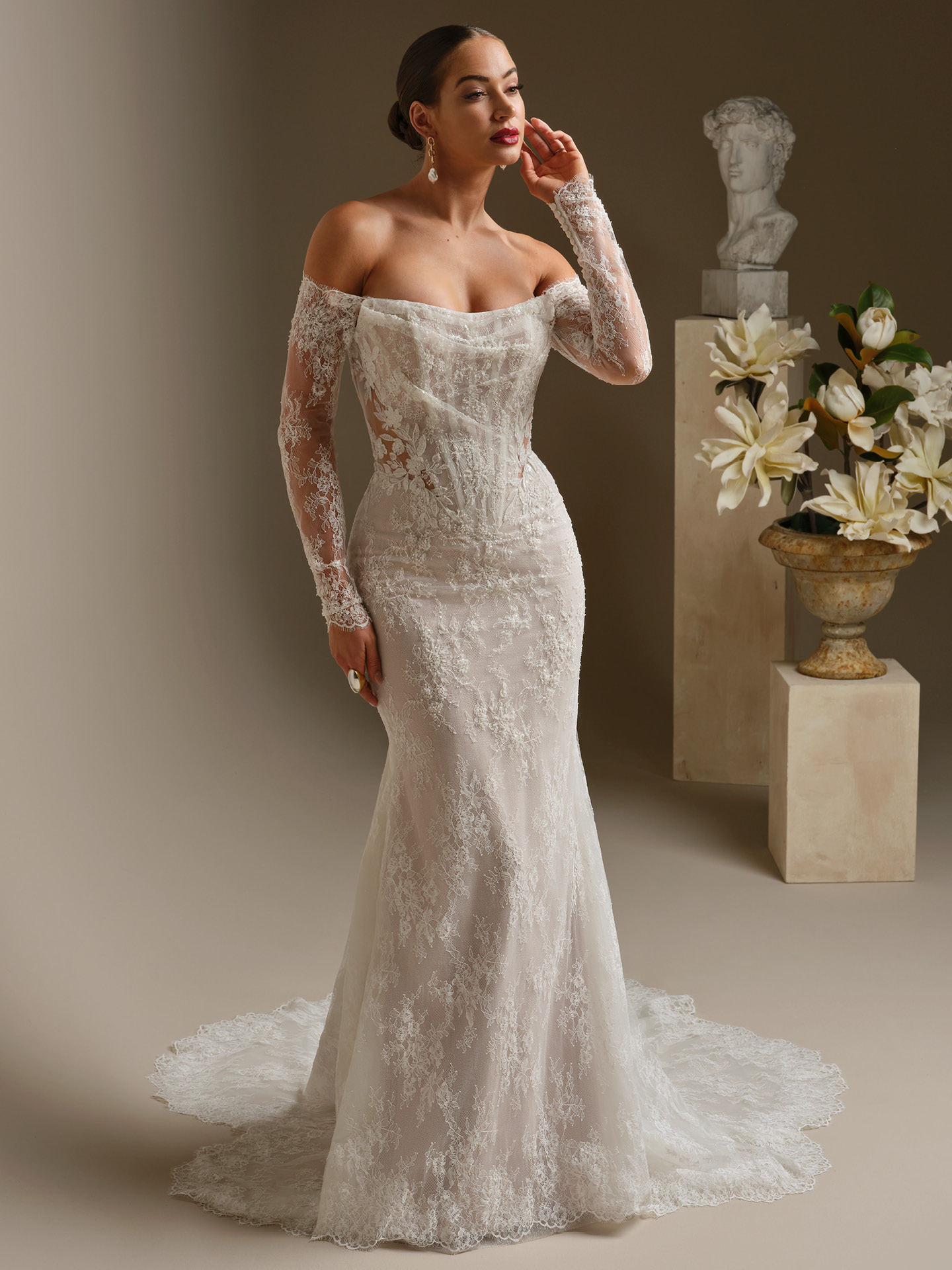 Dublin fit-and-flare wedding dress by Sottero and Midgley with off-the-shoulder lace sleeves, sheer corset bodice, and fitted silhouette
