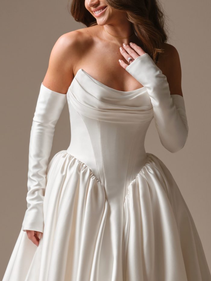 Maggie Sottero Hudson ballgown wedding dress with detachable off-the-shoulder sleeves and strapless cowl neckline in ivory