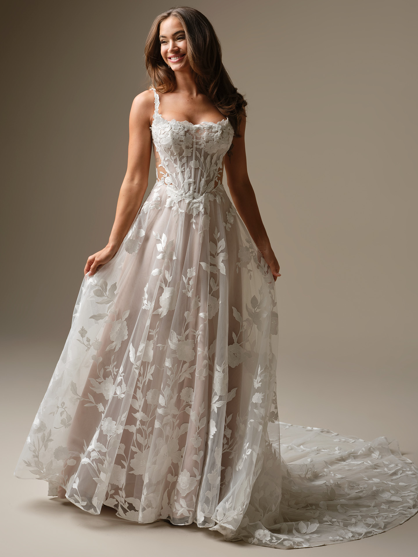Maggie Sottero Natalie Marie A-line wedding dress featuring soft illusion layers, delicate floral appliqués, and a romantic flowing skirt for an effortlessly ethereal bridal look