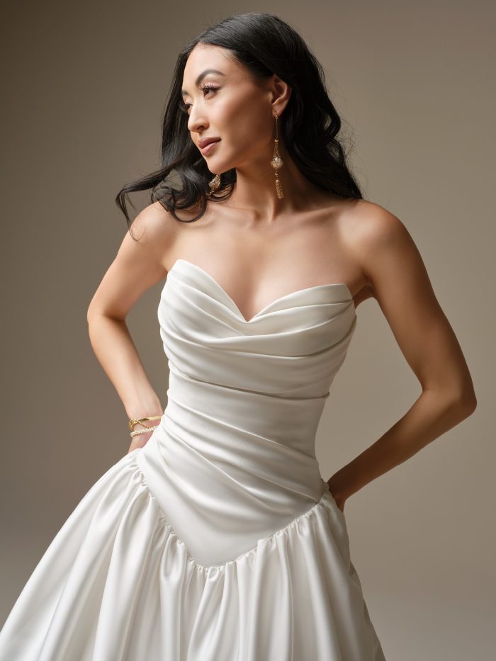 Maggie Sottero Pasadena satin goddess wedding dress close-up of sweetheart neckline with asymmetric ruched bodice and basque waist detail