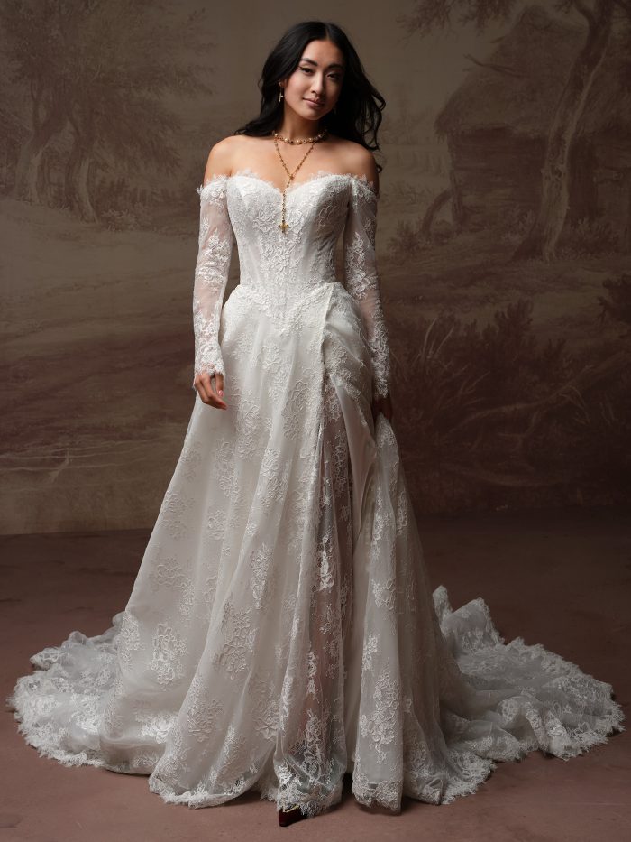 Sottero and Midgley Vespera A-line wedding dress in layered lace with a sweetheart neckline, detachable sheer lace off-the-shoulder long sleeves, and a voluminous cathedral train with eyelash lace trim.