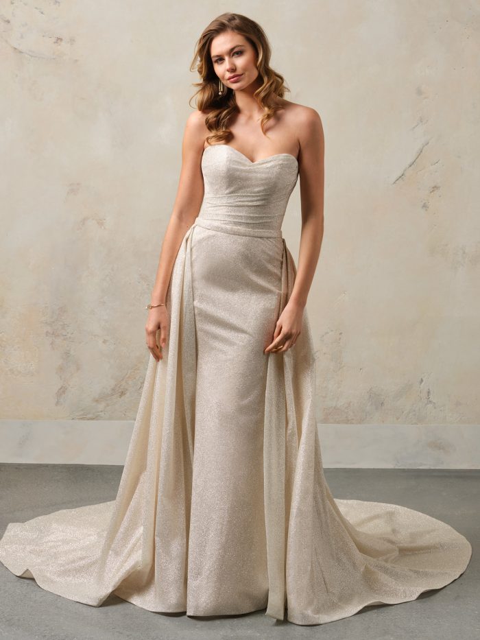 Front view of the Anniston Lane fit-and-flare wedding dress by Maggie Sottero, featuring a strapless sweetheart neckline, ruched bodice, fitted shimmer skirt, and detachable overskirt train.