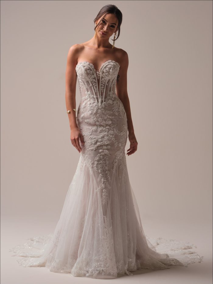 Maggie Sottero Benjie Royale Fit and Flare wedding dress in ivory, front view featuring a strapless sweetheart sheer corset bodice with heavily beaded lace appliqué, body-skimming fit and flare silhouette with all-over beaded lace, and cathedral train with scalloped lace border.