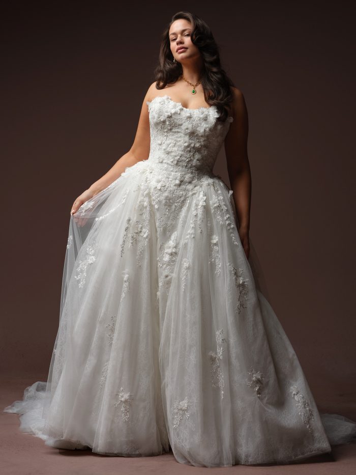 Maggie Sottero Benton ballgown wedding dress in ivory, curve fit — strapless bodice covered in 3D floral appliqués and lace, full tulle ballgown skirt with scattered floral embroidery and train."