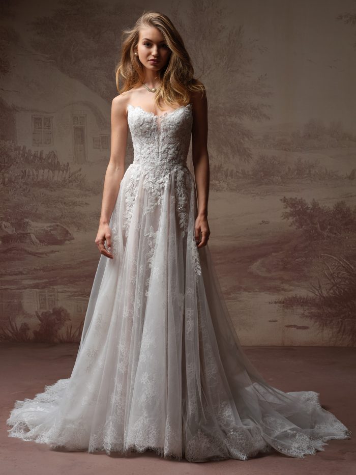 Maggie Sottero Hadley A-Line wedding dress in ivory, front view featuring a strapless sweetheart sheer corset bodice with 3D floral lace appliqué, soft tulle A-line skirt with scattered lace appliqués, and scalloped lace cathedral train.