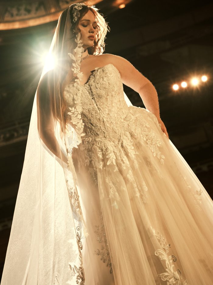 Maggie Sottero Kate A-line wedding dress in ivory, curve fit — close-up of the strapless lace bodice with intricate beaded floral appliqués, worn by a plus-size model with a matching lace-edged veil.