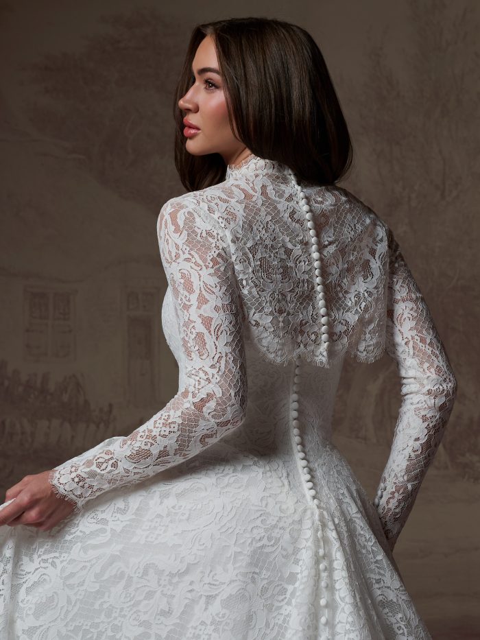 Back view of the Serena gown by Maggie Sottero, showing the high lace collar, button-covered back, and full lace skirt.