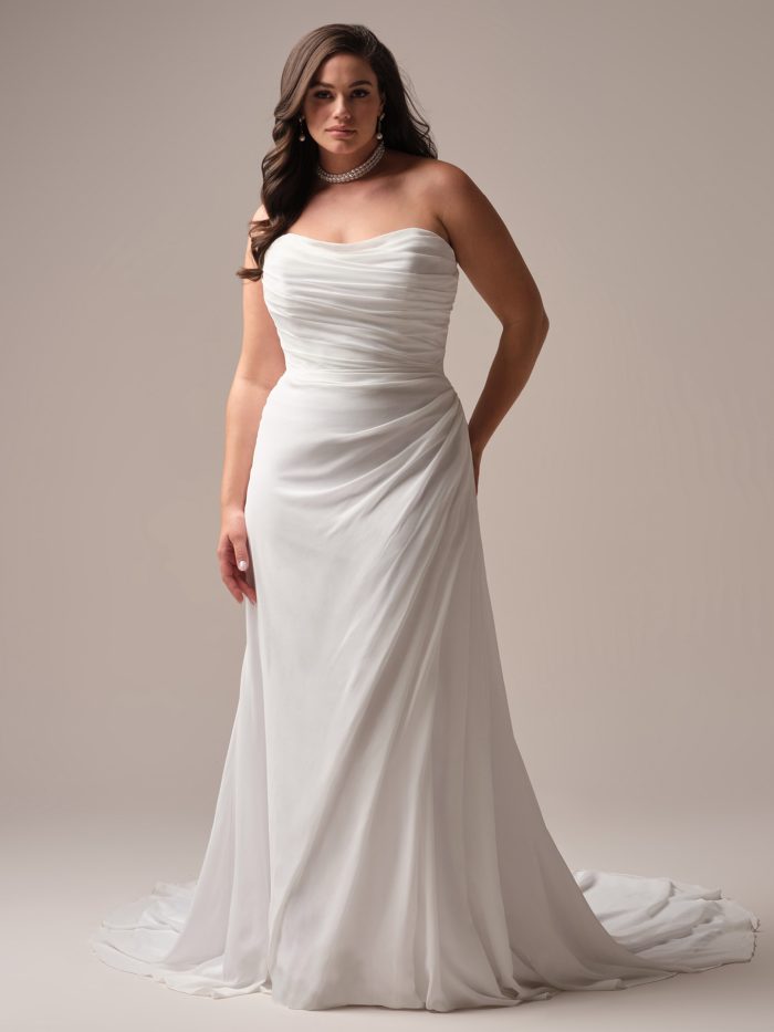Rebecca Ingram Francesca A-line wedding dress in diamond white, curve fit — strapless sweetheart neckline with draped bodice, form-fitting chiffon skirt with sweeping train, worn with a pearl choker.