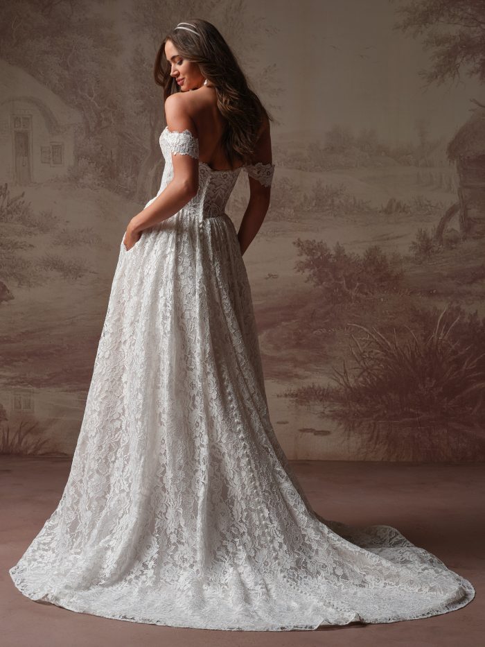 Rebecca Ingram Narelle A-Line wedding dress in ivory, back view showing off-the-shoulder lace straps, open back, all-over lace A-line skirt with pockets, and cathedral train with scalloped lace hem.