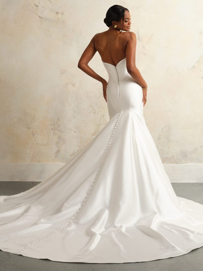 Back view of the Giselle wedding dress by Sottero and Midgley, showing a strapless sweetheart back with covered button closure down the fitted mermaid skirt and flared train.