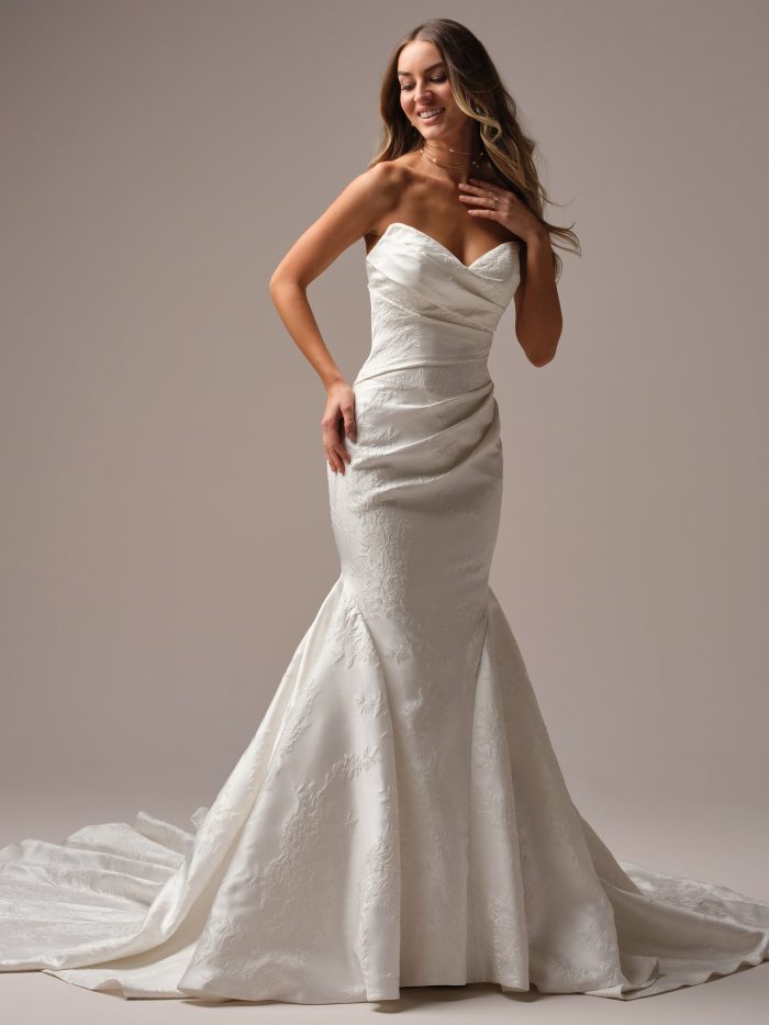 Front view of the Giselle Marie fit-and-flare wedding dress by Sottero and Midgley, featuring a draped strapless sweetheart neckline and fitted floral jacquard mermaid skirt with dramatic flared train.
