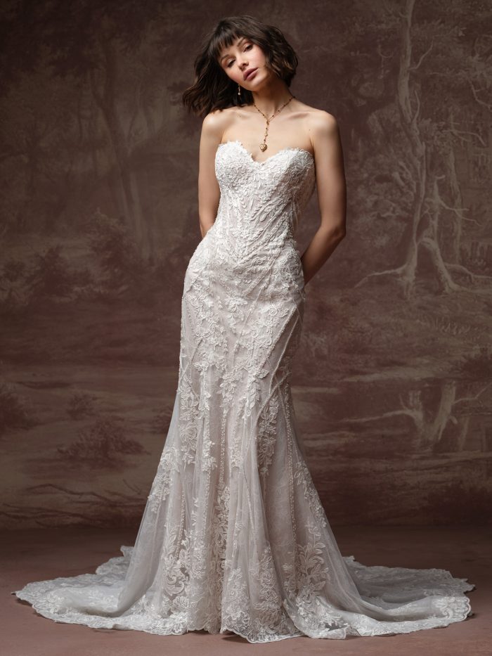 Bride wearing the Hester fit-and-flare wedding dress, featuring a strapless sweetheart lace bodice with a fitted lace skirt and a scalloped lace train.