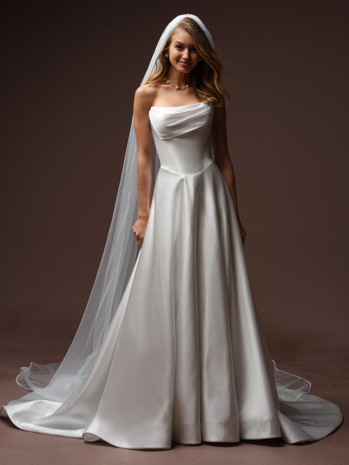 Bride wearing the Amor cathedral wedding veil by Maggie Sottero from the Essentials Edit collection, paired with a strapless satin A-line gown and pearl necklace.