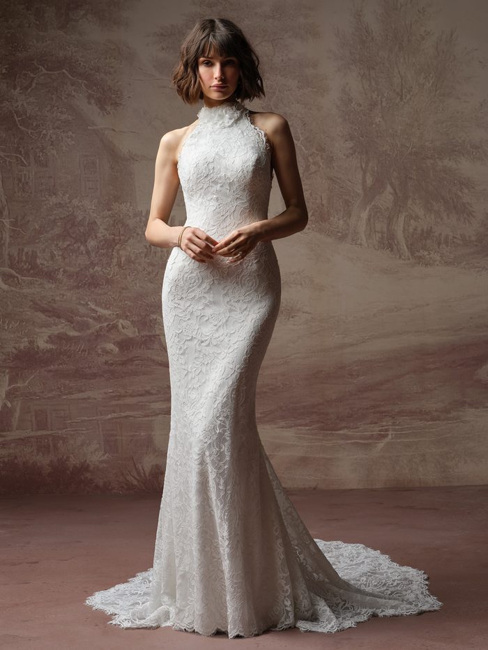 Bride wearing the Anya sheath wedding dress by Maggie Sottero, featuring a high halter lace neckline with a ruffled collar and a fitted lace sheath skirt with a train.