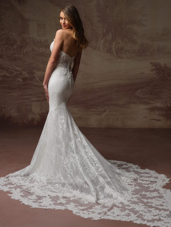 Back view of bride wearing the Collette strapless lace sheath wedding dress by Maggie Sottero, featuring a sweetheart back neckline, floral lace appliqué, and a scalloped lace hem train.