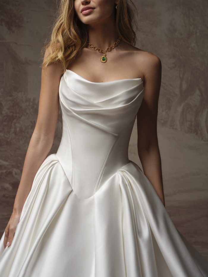 Close-up of the Fiorita ballgown wedding dress by Maggie Sottero, showing the draped cowl neckline and structured satin bodice detail.