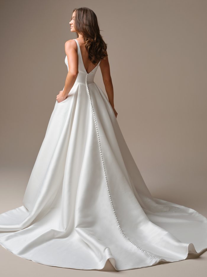 Back view of the Galina A-line wedding dress by Maggie Sottero, showing a low V-back with covered buttons running down the bodice and a sweeping satin train.