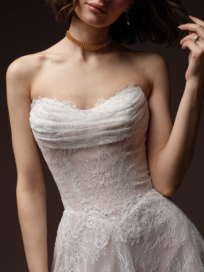 Close-up of the Maelle A-line wedding dress by Maggie Sottero, showing the strapless ruched lace bodice with a scalloped neckline.