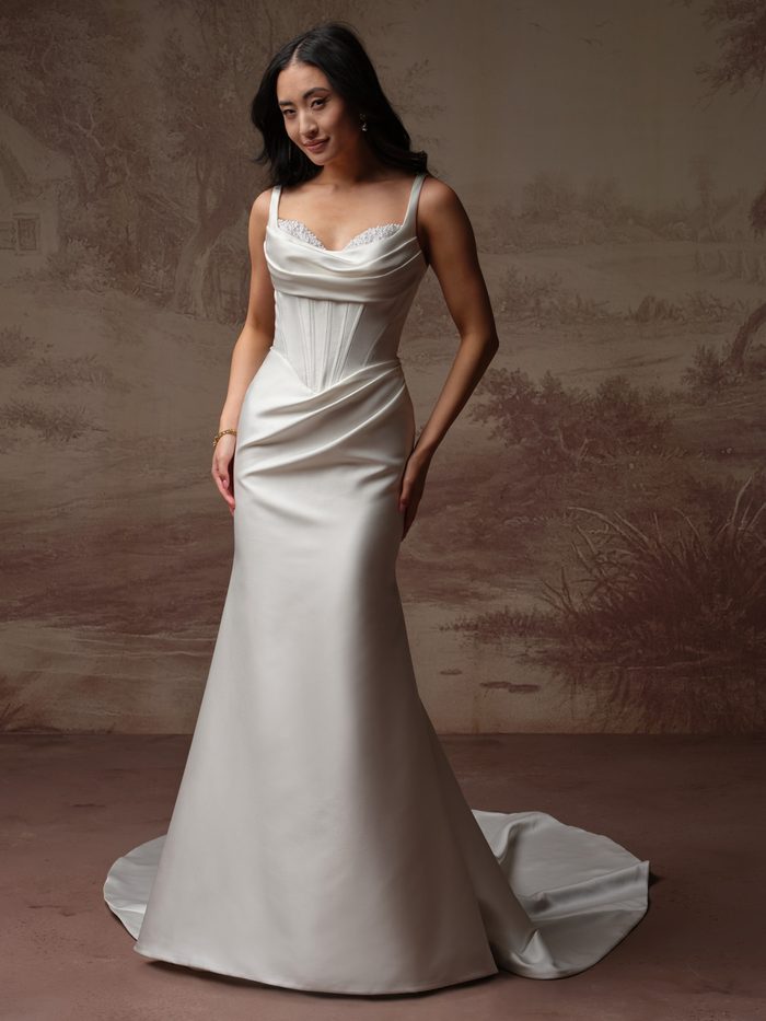 Bride wearing the Melissa Marie fit-and-flare wedding dress by Maggie Sottero, featuring a cowl neckline with pearl-beaded trim, a corset bodice, and a satin trumpet skirt with draped ruching and a train.