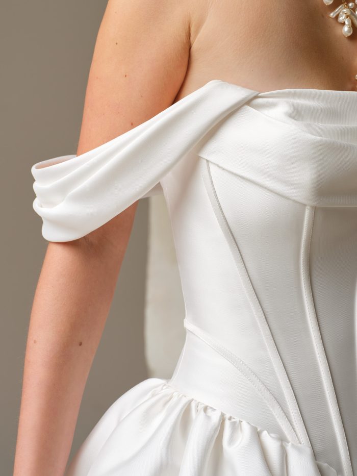 Close-up of the detachable off-the-shoulder tie sleeves for the Sinclaire wedding dress by Maggie Sottero, showing the satin strap and tie detail.