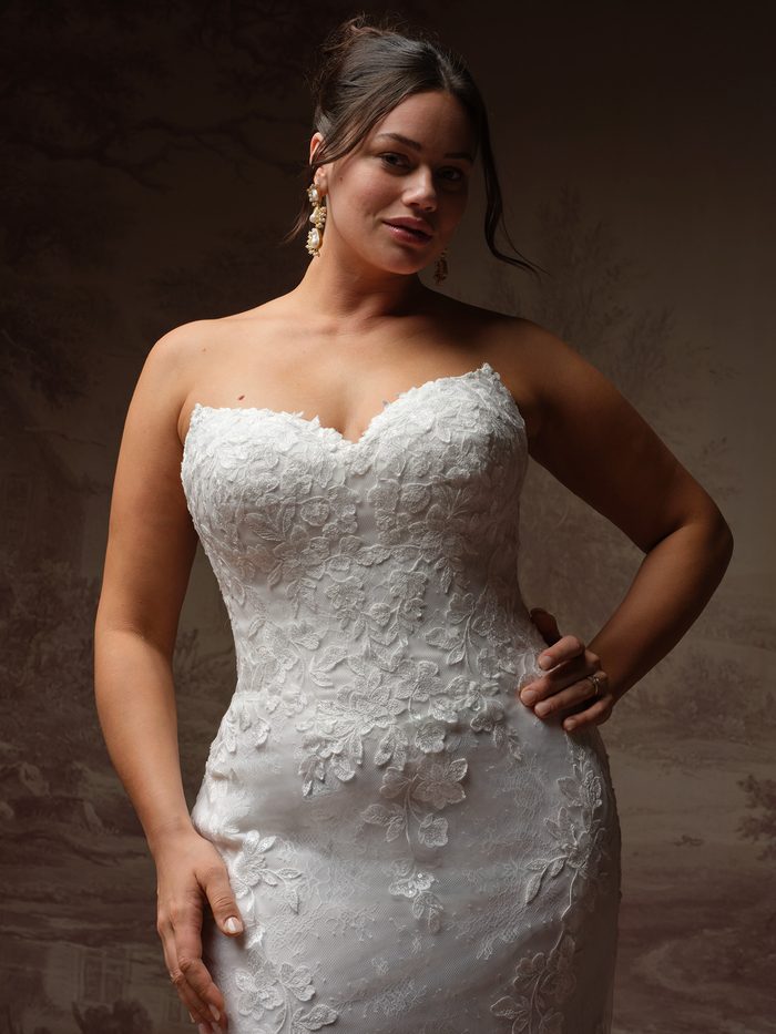 Close-up of the Brandy fit-and-flare wedding dress by Rebecca Ingram in a curve size, showing the strapless sweetheart lace bodice detail.