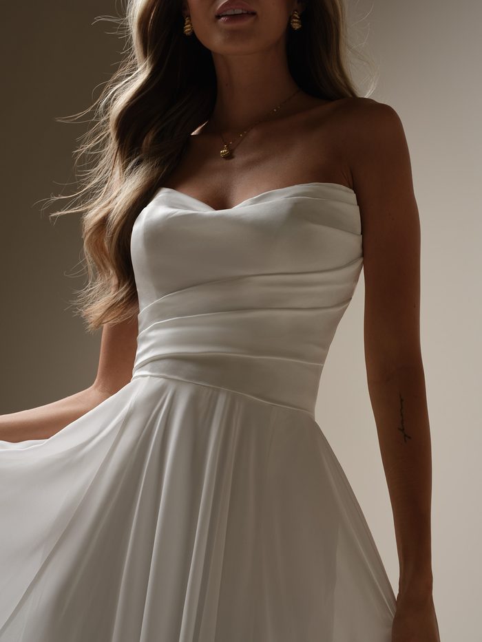 Close-up of the ruched bodice and sweetheart neckline on the chiffon Melody wedding dress by Rebecca Ingram.
