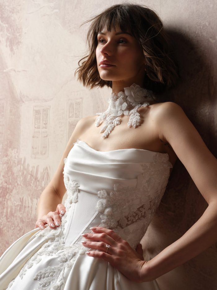 Editorial bridal portrait featuring the Burke Bridal Choker by Sottero and Midgley, highlighted by three-dimensional floral appliqués and shimmering leaf details, paired with the Burke Lane ballgown wedding dress with a draped satin bodice and textured floral embroidery.