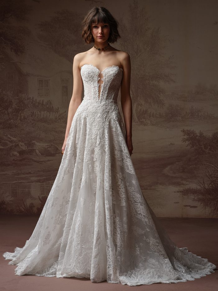 Bride wearing the Keeva A-line wedding dress by Sottero and Midgley, featuring a strapless lace bodice with a plunging sweetheart neckline and a full lace A-line skirt with a train.