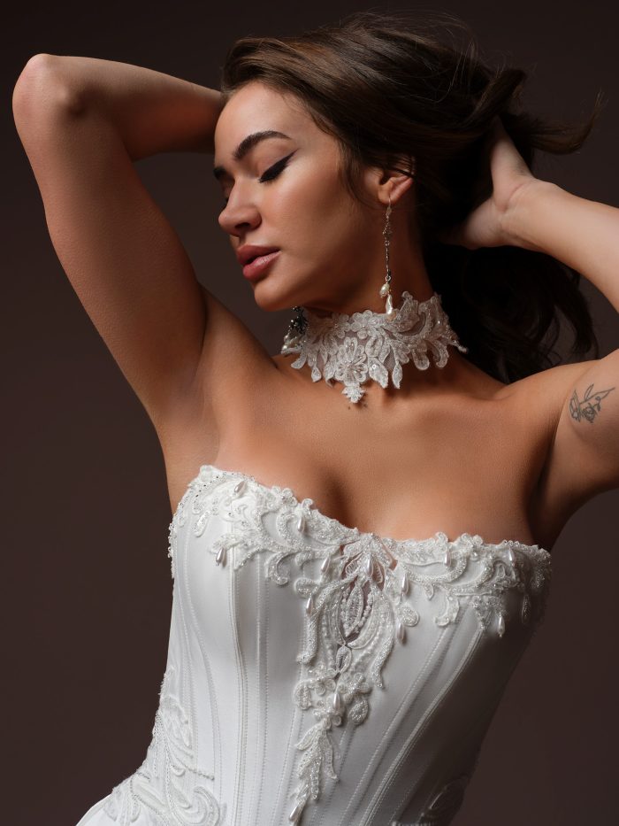 Sandrine ballgown wedding dress by Sottero and Midgley with a beaded lace corset bodice and pearl accents, styled with a statement floral lace bridal choker and elegant drop earrings.