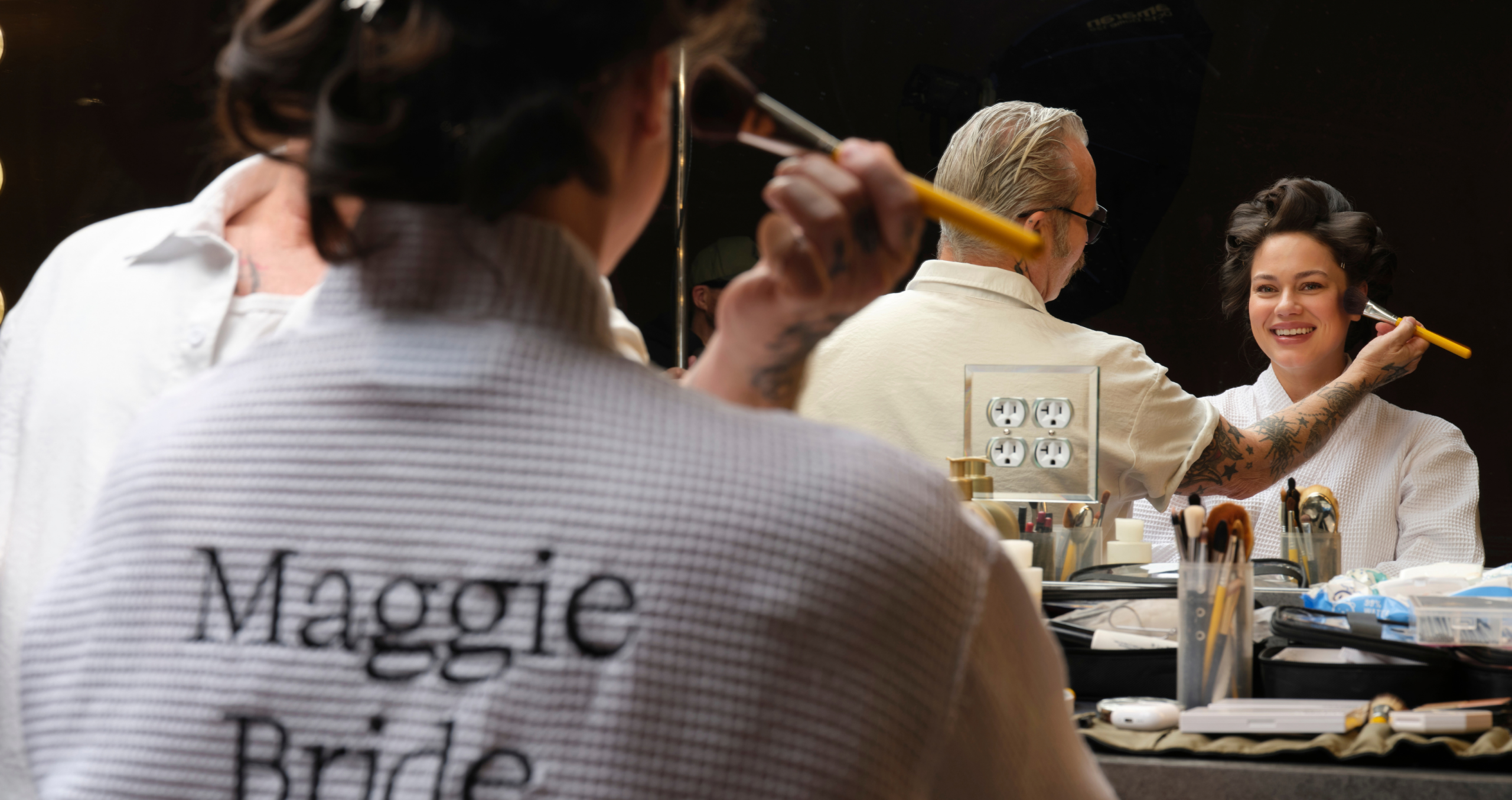 Bride getting ready with a makeup artist before her wedding, highlighting last-minute bridal preparations and wedding day emergency essentials.