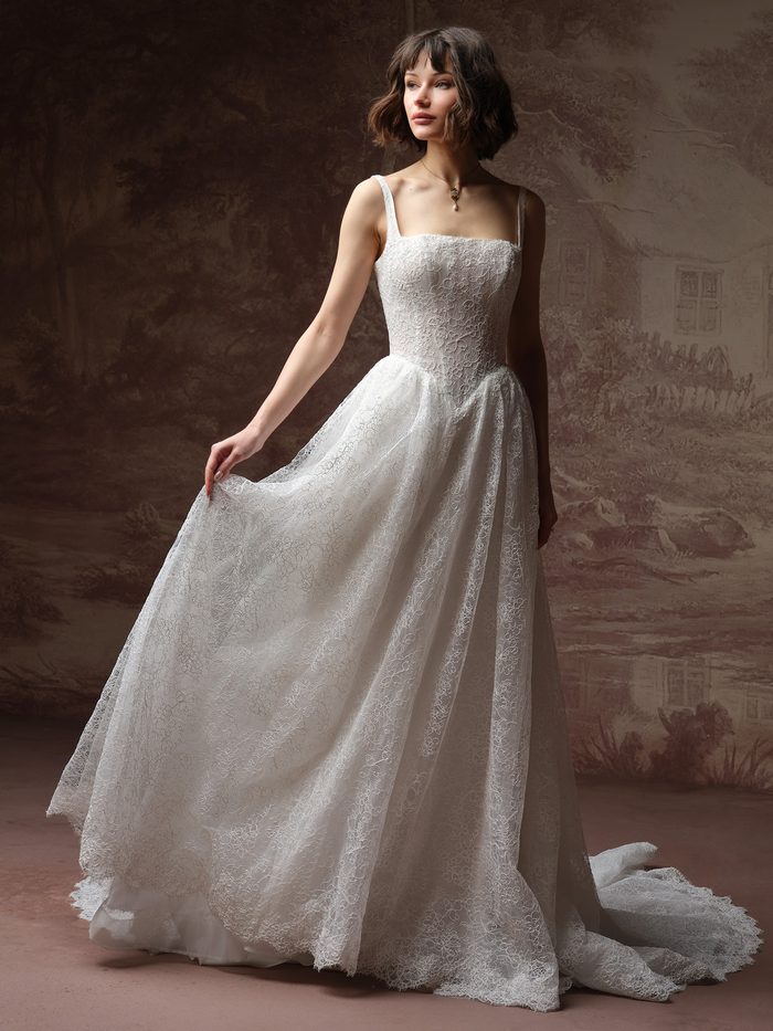 Autumn by Maggie Sottero ballgown wedding dress featuring a square neckline, lace shoulder straps, and an allover lace A-line silhouette with a softly gathered skirt and chapel-length train. Front view shown in a studio setting.