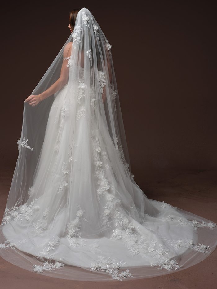 Back view of the Fern wedding dress with a floral-appliqué veil and flowing A-line train.